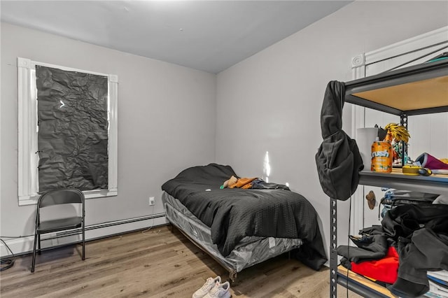 bedroom with hardwood / wood-style flooring and a baseboard radiator