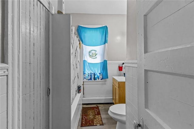 bathroom with hardwood / wood-style flooring, vanity, tile walls, and toilet