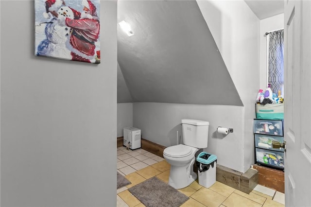 bathroom with tile patterned flooring, lofted ceiling, and toilet