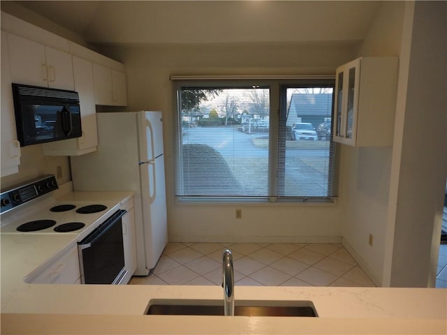 kitchen with sink, light tile patterned floors, white cabinets, and white range with electric cooktop