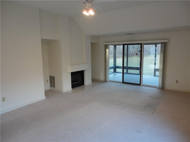 unfurnished living room featuring vaulted ceiling, light carpet, and ceiling fan