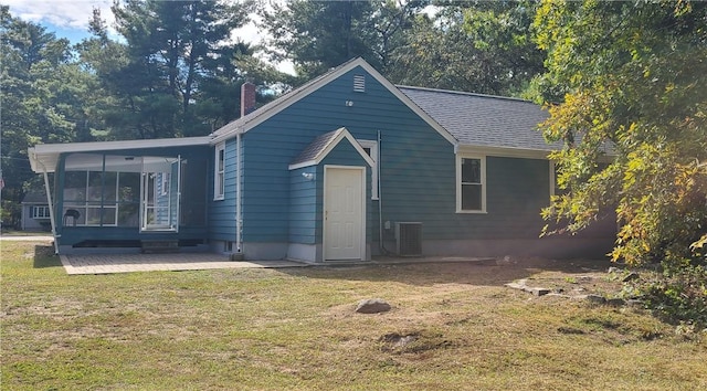 view of front facade with central AC, a front yard, and a patio area