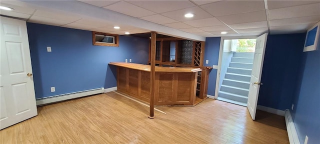 bar featuring a drop ceiling, wood-type flooring, and baseboard heating