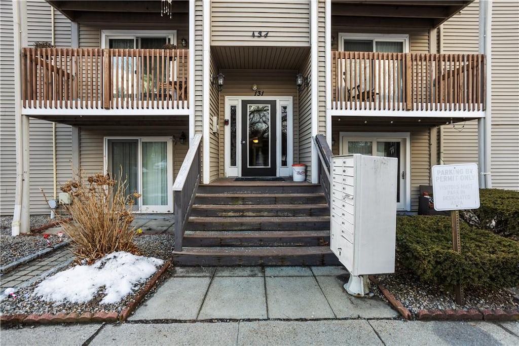 view of exterior entry with a balcony