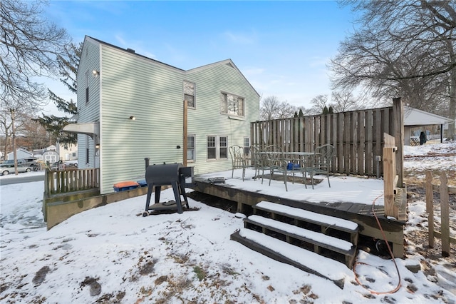 snow covered house featuring a wooden deck