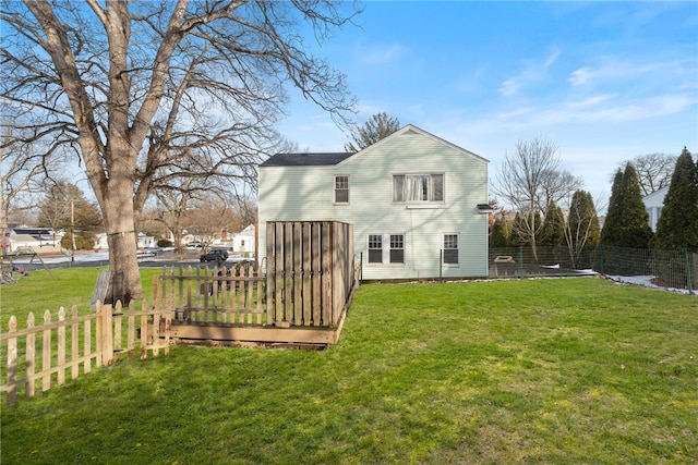 back of property with a deck and a lawn