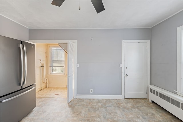 spare room featuring radiator and ceiling fan