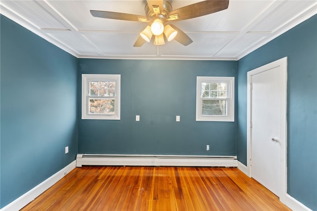 empty room with ceiling fan, a baseboard heating unit, and light hardwood / wood-style floors