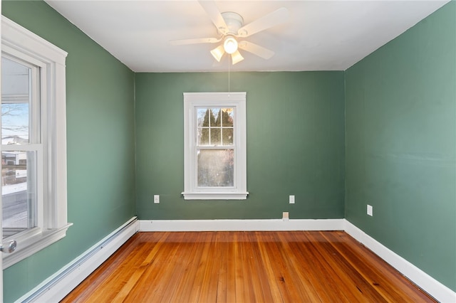 empty room with ceiling fan, hardwood / wood-style floors, and baseboard heating