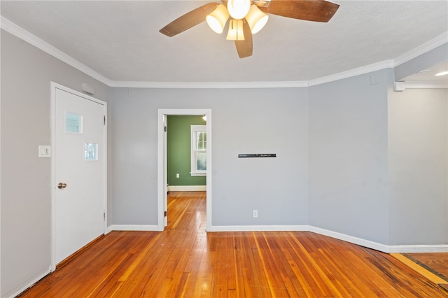 spare room with hardwood / wood-style floors, crown molding, and ceiling fan