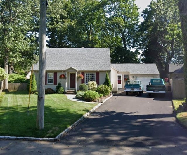 view of front of home with a garage and a front lawn