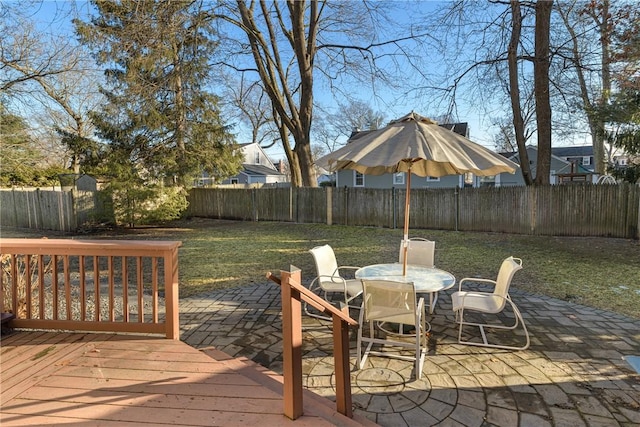 wooden deck with a patio area and a lawn