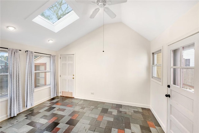 empty room featuring ceiling fan and lofted ceiling with skylight