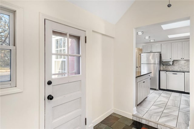 entryway featuring lofted ceiling with skylight