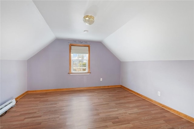 additional living space featuring light hardwood / wood-style flooring, a baseboard radiator, and lofted ceiling