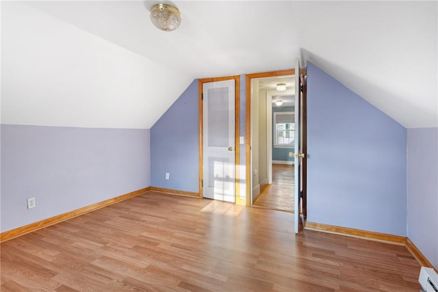 bonus room featuring vaulted ceiling, a baseboard heating unit, and light hardwood / wood-style floors