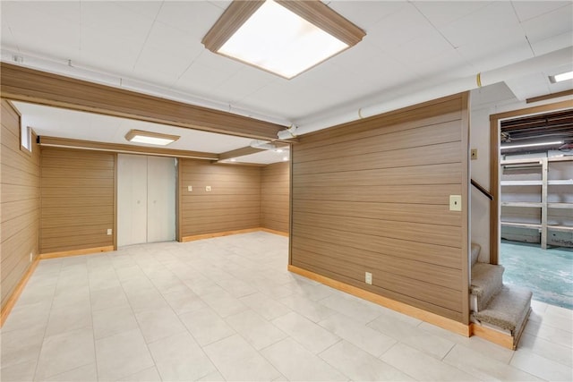 basement featuring wood walls