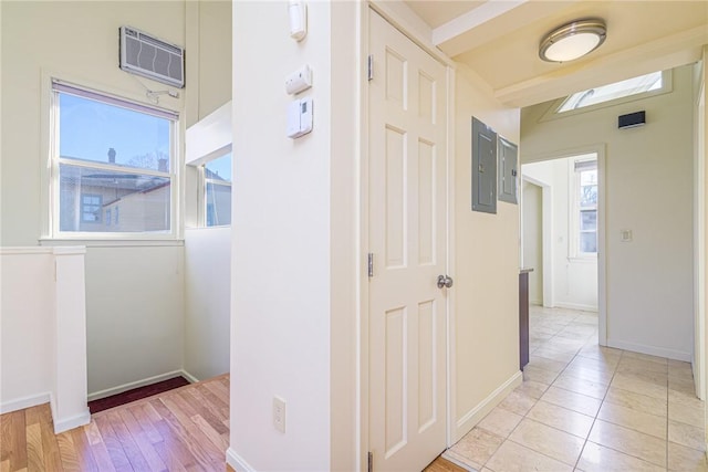 hallway with light tile patterned floors, electric panel, and an AC wall unit