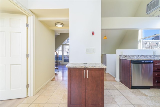 kitchen with lofted ceiling, light tile patterned floors, hanging light fixtures, light stone counters, and stainless steel dishwasher