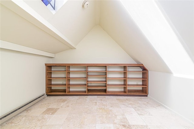 additional living space featuring lofted ceiling with skylight and baseboard heating