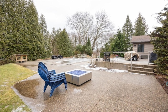 view of patio featuring an outbuilding and a fire pit