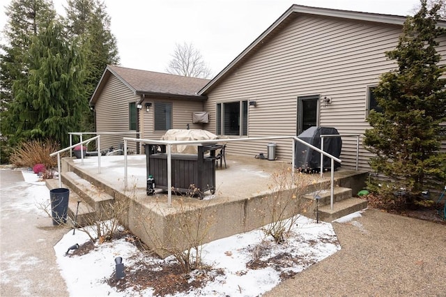 view of snow covered rear of property