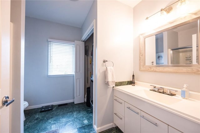 bathroom featuring vanity, a shower with shower door, and toilet