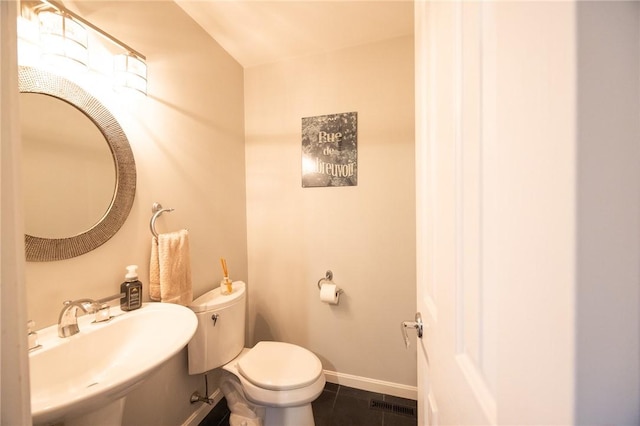 bathroom featuring toilet, tile patterned flooring, and sink