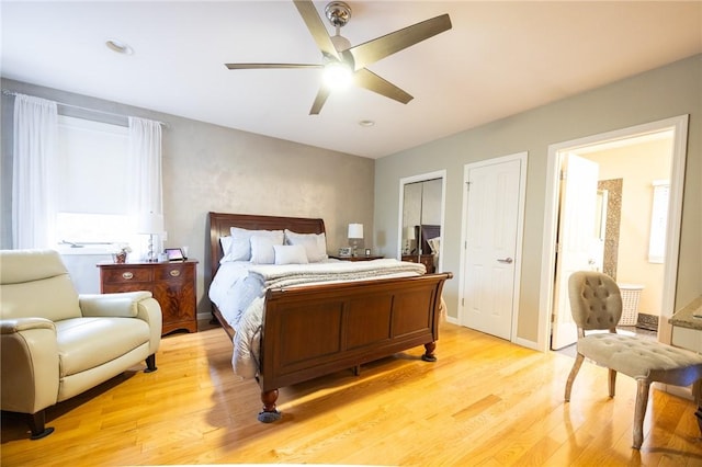 bedroom featuring ceiling fan, light hardwood / wood-style floors, and ensuite bath