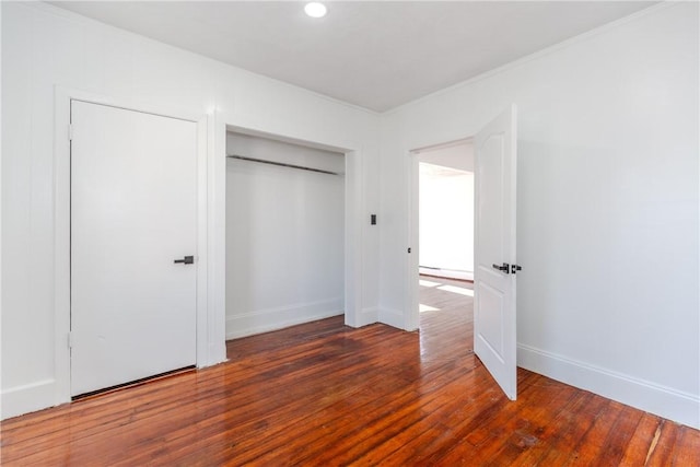 unfurnished bedroom with dark wood-type flooring and a closet