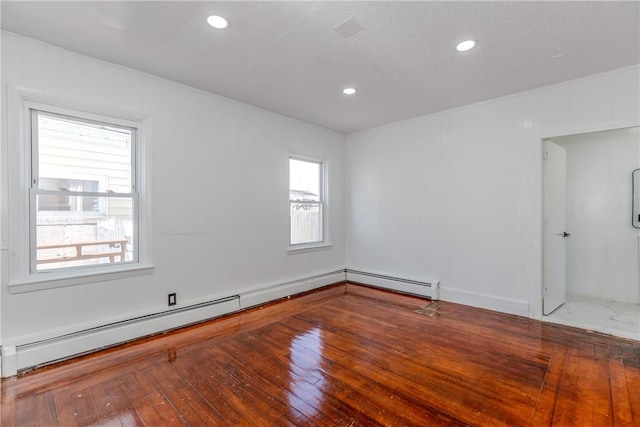 spare room featuring hardwood / wood-style flooring and baseboard heating