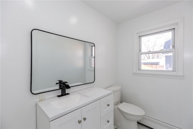 bathroom featuring vanity, a baseboard heating unit, and toilet