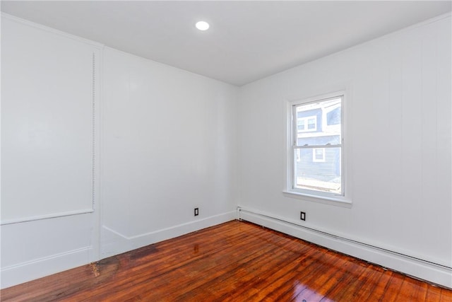 empty room with hardwood / wood-style floors and a baseboard radiator