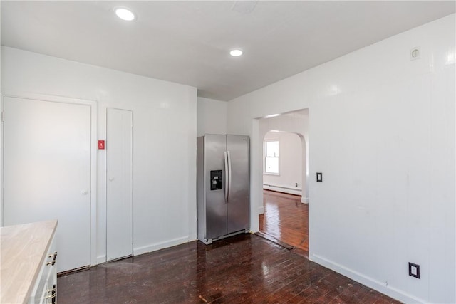 kitchen with stainless steel refrigerator with ice dispenser, dark hardwood / wood-style floors, and a baseboard radiator