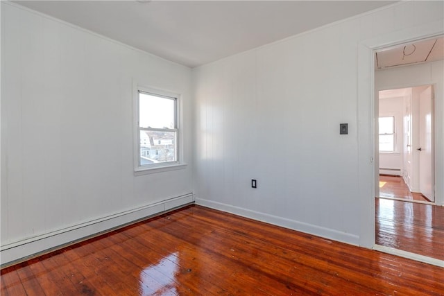 empty room with hardwood / wood-style flooring and baseboard heating