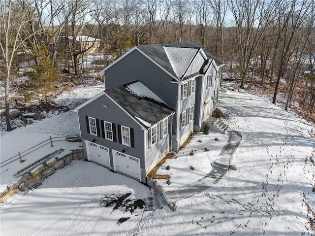 exterior space with roof with shingles and an attached garage