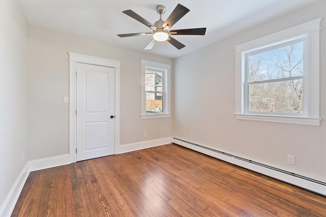 spare room with hardwood / wood-style flooring, a baseboard heating unit, and ceiling fan