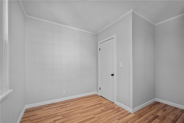 spare room with ornamental molding and light hardwood / wood-style floors