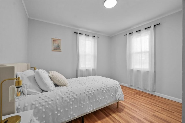 bedroom with wood-type flooring and ornamental molding