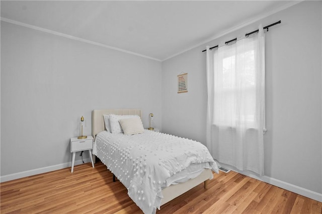 bedroom featuring ornamental molding and hardwood / wood-style floors