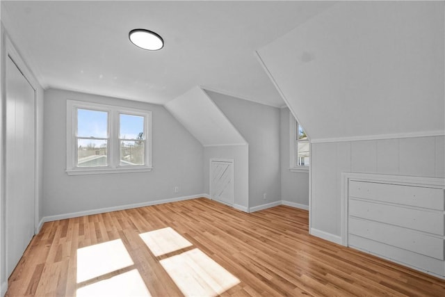 additional living space featuring lofted ceiling and light hardwood / wood-style floors