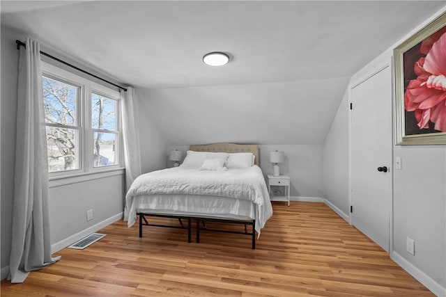 bedroom featuring lofted ceiling and light hardwood / wood-style floors