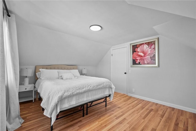 bedroom featuring lofted ceiling and light hardwood / wood-style floors