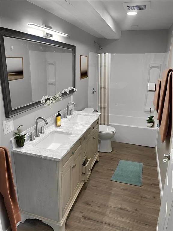 full bathroom featuring hardwood / wood-style flooring, shower / tub combination, vanity, and toilet