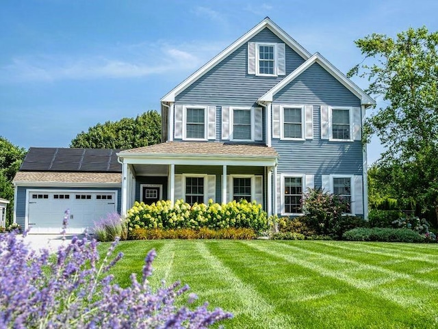 view of front of home with a garage, a front lawn, solar panels, and covered porch