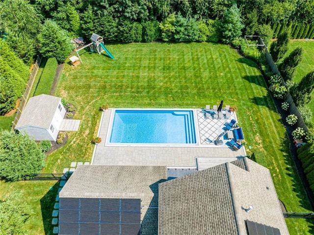 view of swimming pool with a lawn and a playground