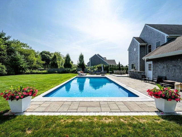 view of swimming pool featuring a yard and a patio area