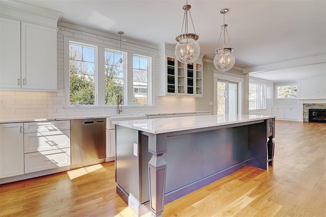 kitchen featuring light hardwood / wood-style flooring, dishwasher, hanging light fixtures, a center island, and white cabinets