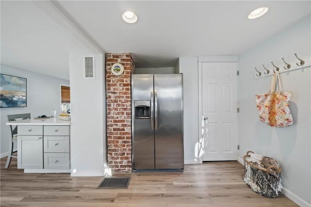 kitchen featuring gray cabinets, stainless steel refrigerator with ice dispenser, and light hardwood / wood-style flooring