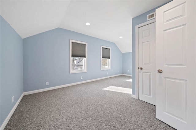 additional living space featuring vaulted ceiling and carpet